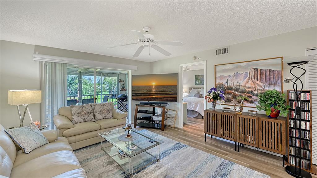 6505 Stone River Road, Unit 209 Bradenton, FL 34203 - Photo 12 of 47 a living room with furniture and a flat screen tv