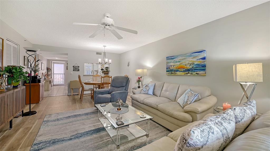 6505 Stone River Road, Unit 209 Bradenton, FL 34203 - Photo 17 of 47 a living room with furniture and a chandelier