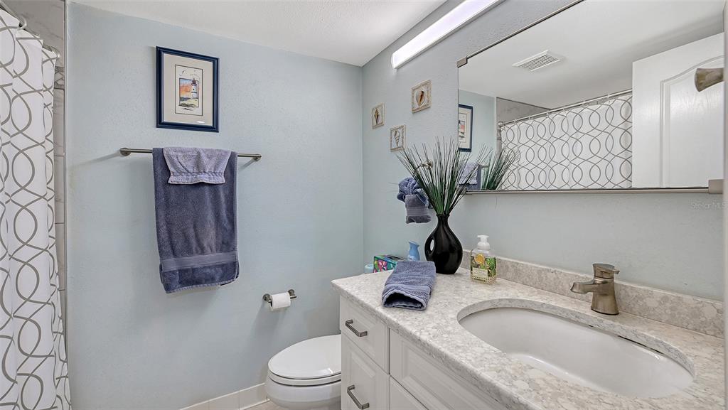 6505 Stone River Road, Unit 209 Bradenton, FL 34203 - Photo 22 of 47 a bathroom with a granite countertop sink a toilet and mirror