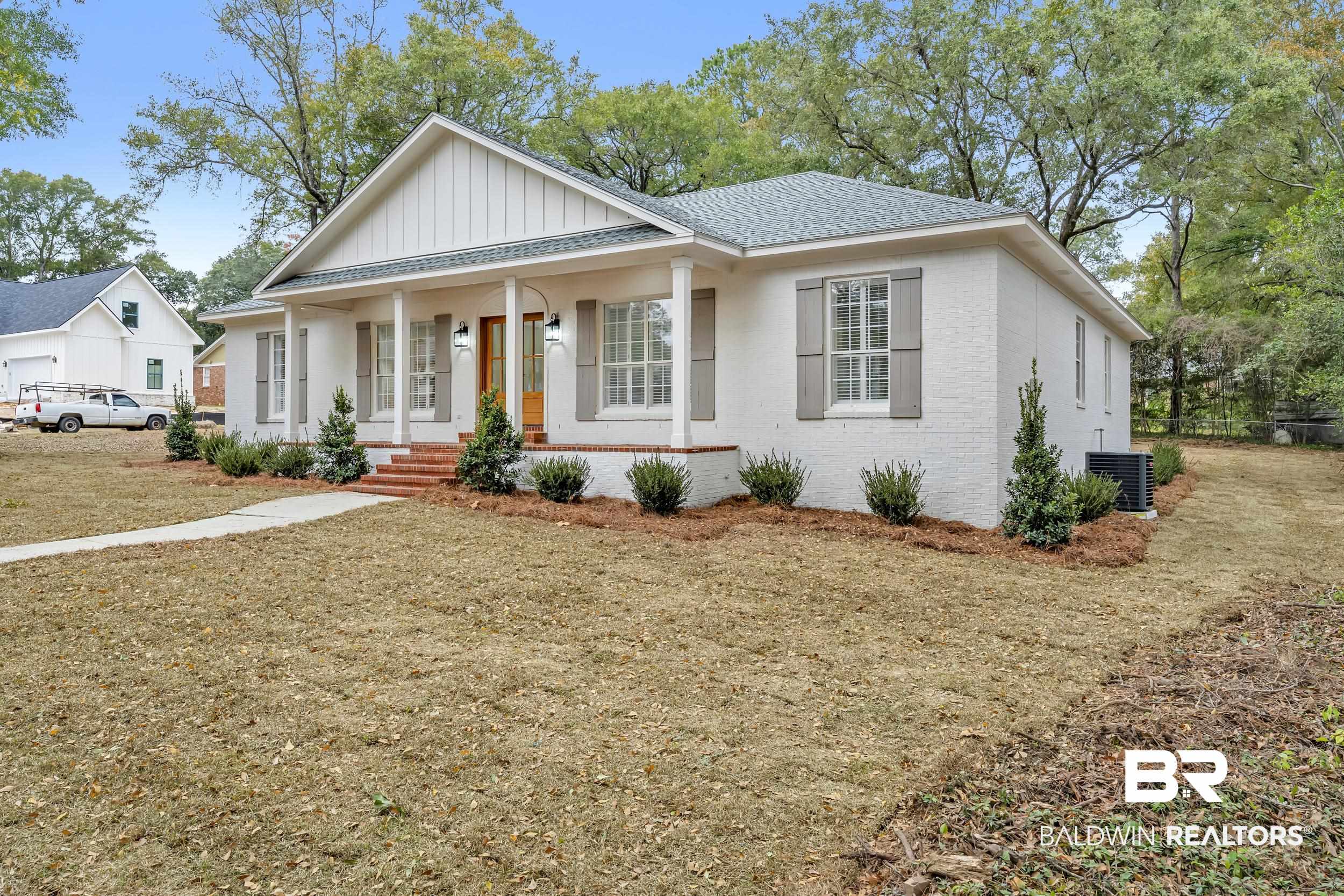 4924 Brooke Court Mobile, AL 36618 - Photo 3 of 34 View of front of property with covered porch, brick siding, a front yard, and board and batten siding