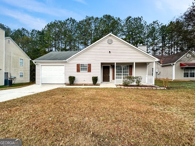 a front view of a house with yard patio and garage