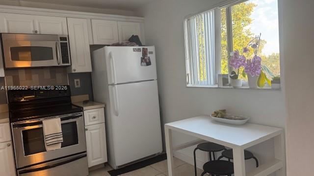 731 North Pine Island Road, Unit 306 Plantation, FL 33324 - Photo 7 of 13 a kitchen with stainless steel appliances a stove a microwave and a refrigerator