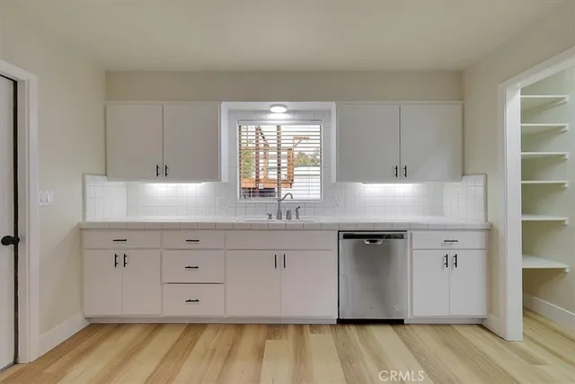 a kitchen with granite countertop white cabinets and window