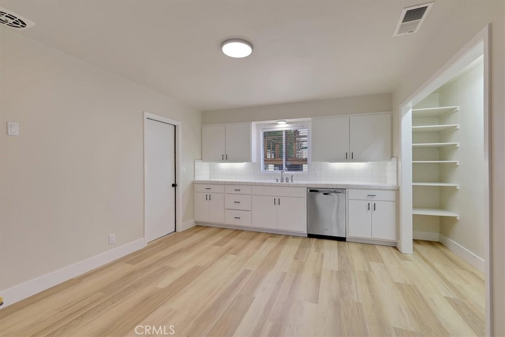 1291 East Chico, CA 95926 - Photo 8 of 29 a large white kitchen with a sink dishwasher a stove and a refrigerator with wooden floor