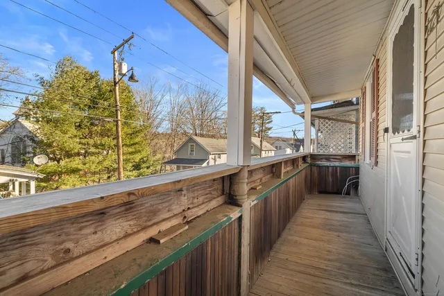 a view of a balcony with wooden floor and fence