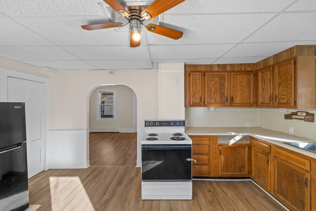 a kitchen with stainless steel appliances granite countertop a sink a stove cabinets and wooden floor