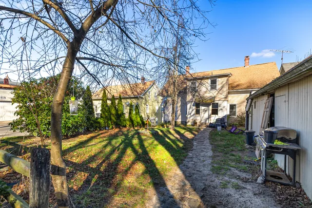 a backyard of a house with table and chairs