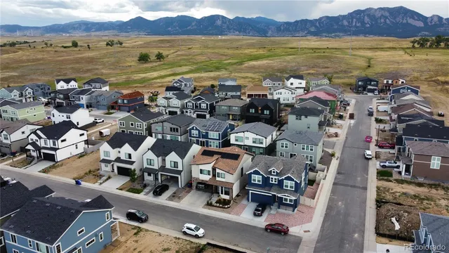 an aerial view of ocean and residential houses with outdoor space
