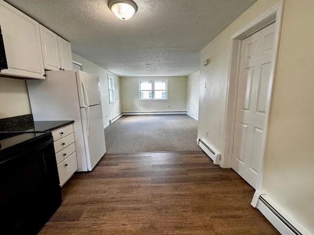 a view of a kitchen with wooden floor and electronic appliances