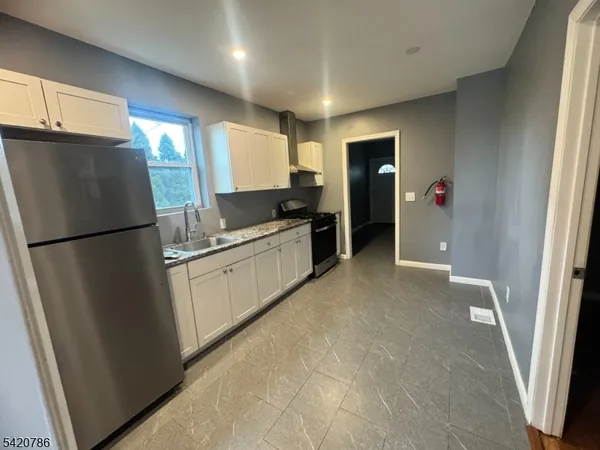 a kitchen with a refrigerator a sink and cabinets