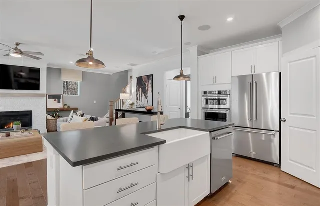 a kitchen with a refrigerator a sink and living room view