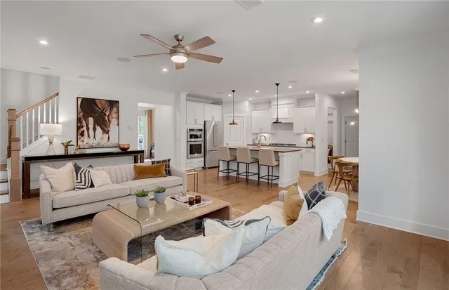 a living room with furniture kitchen view and a chandelier