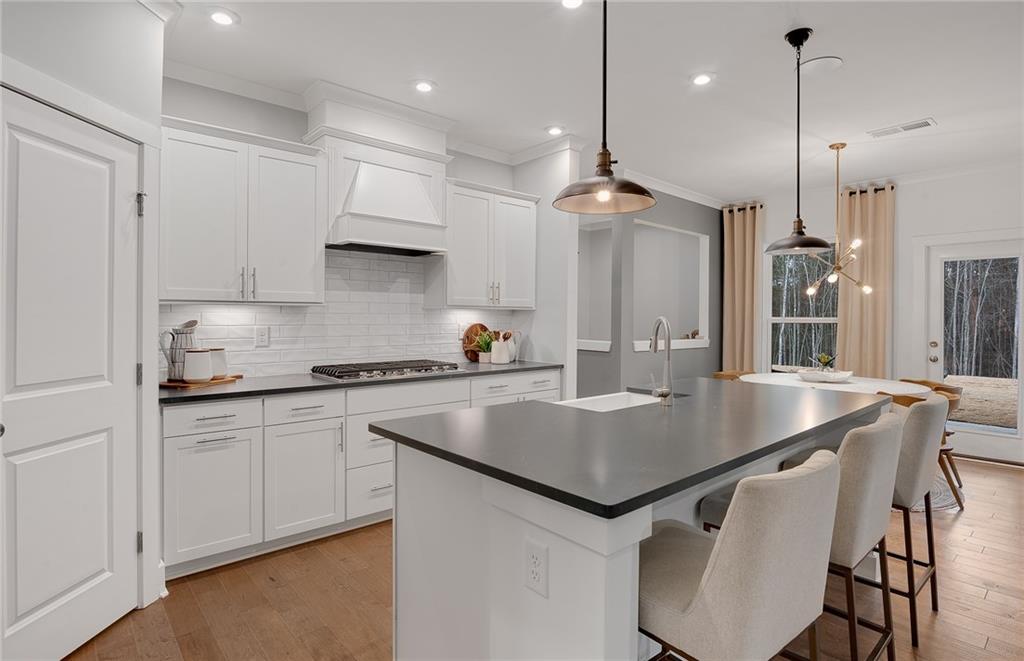 239 Rockledge Bend Southwest Powder Springs, GA 30127 - Photo 9 of 16 a kitchen with stainless steel appliances granite countertop a table chairs sink and stove top oven