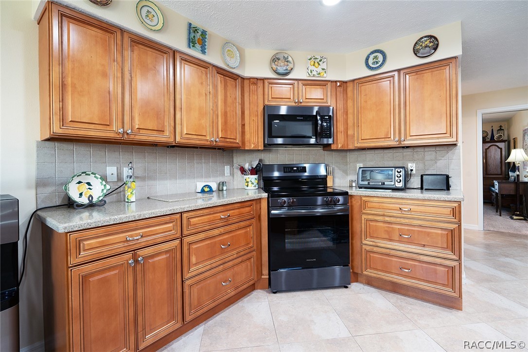 800 Balmoral Court Inverness, FL 34453 - Photo 14 of 72 a kitchen with stainless steel appliances granite countertop a refrigerator and microwave