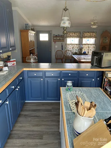 a kitchen with stainless steel appliances granite countertop wooden floors wooden cabinets
