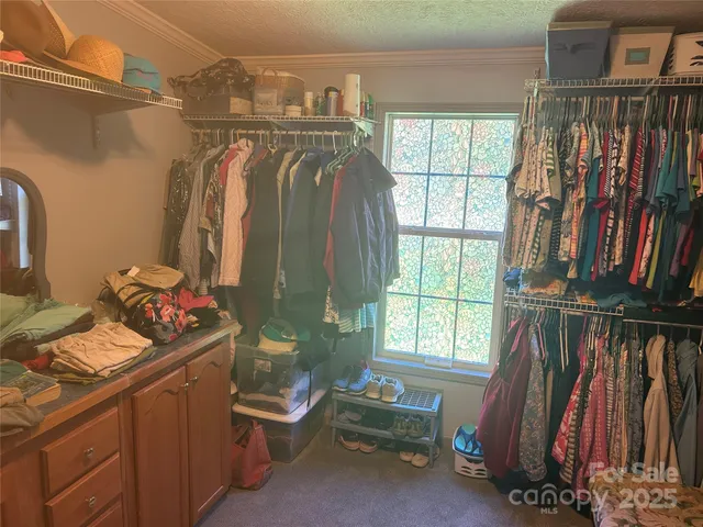 a view of walk in closet with clothes