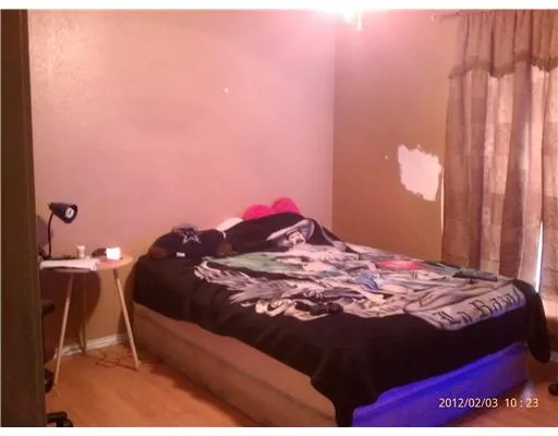 a bedroom with a bed and a lamp