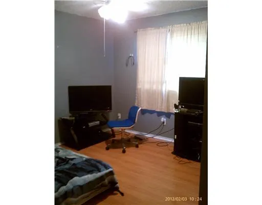 a bedroom with a bed and a television