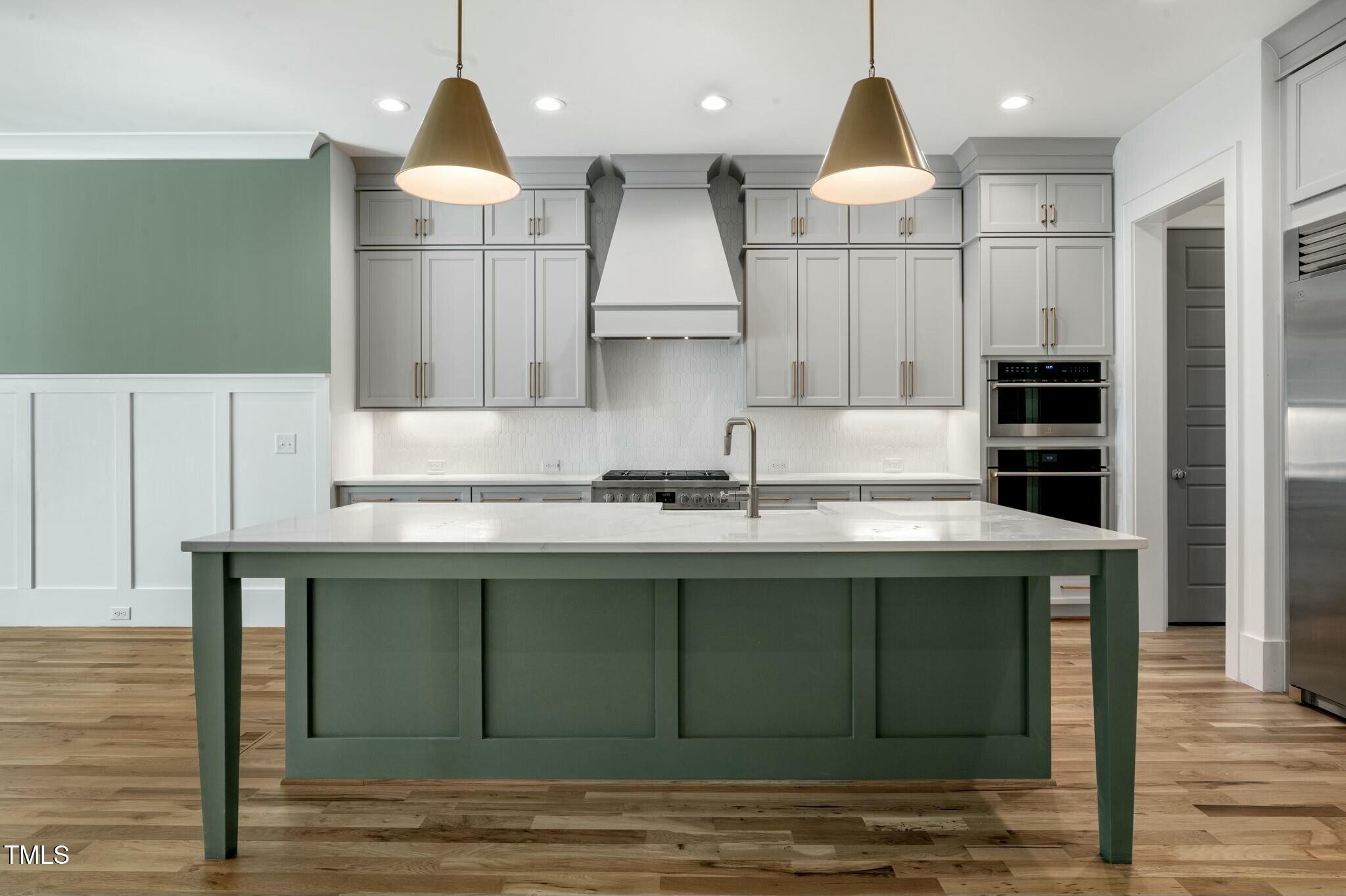 7112 Camp Side Court Raleigh, NC 27613 - Photo 13 of 39 a kitchen with kitchen island granite countertop a sink stainless steel appliances and cabinets