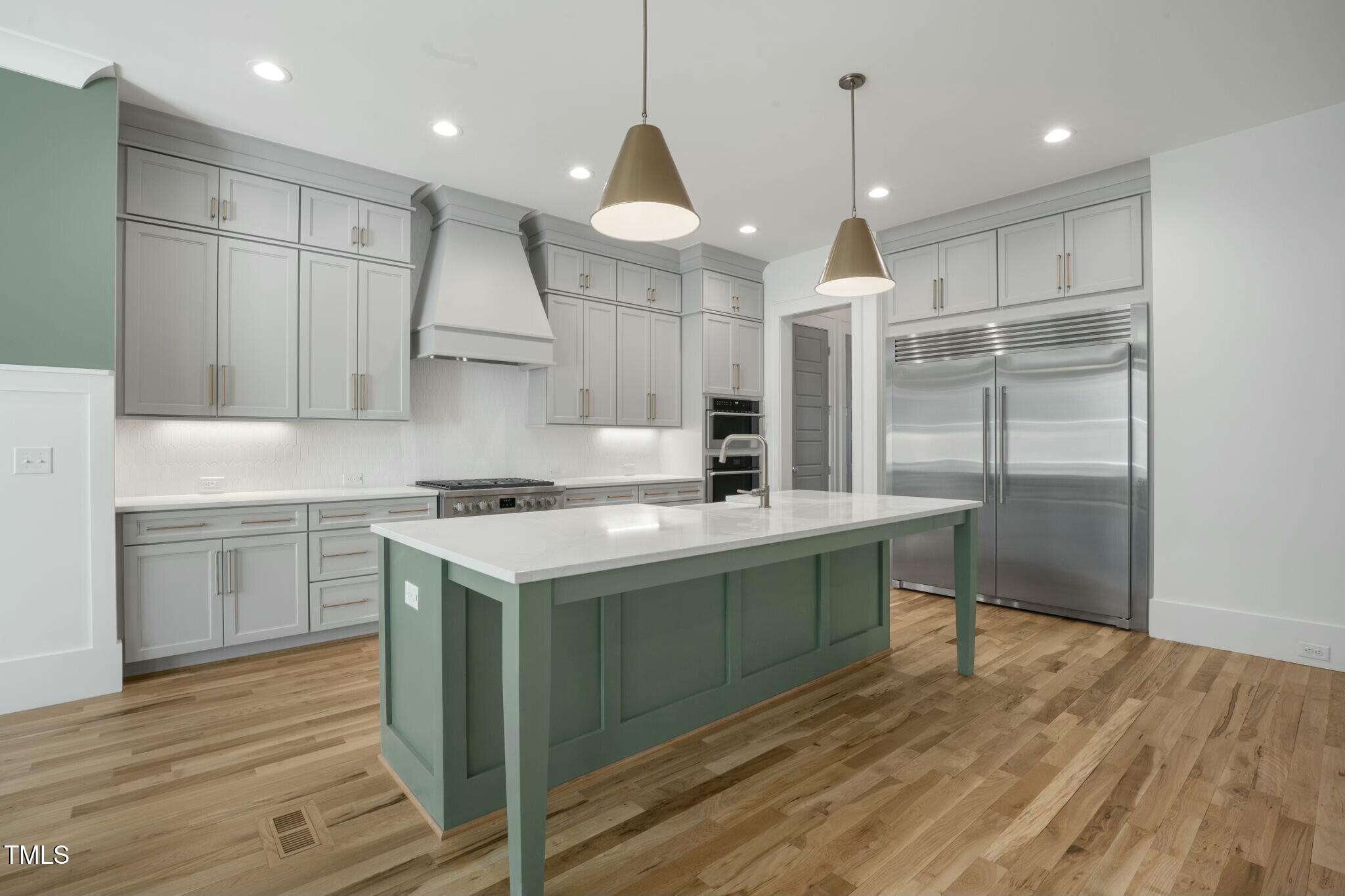 7112 Camp Side Court Raleigh, NC 27613 - Photo 14 of 39 a kitchen with kitchen island a sink stainless steel appliances and cabinets