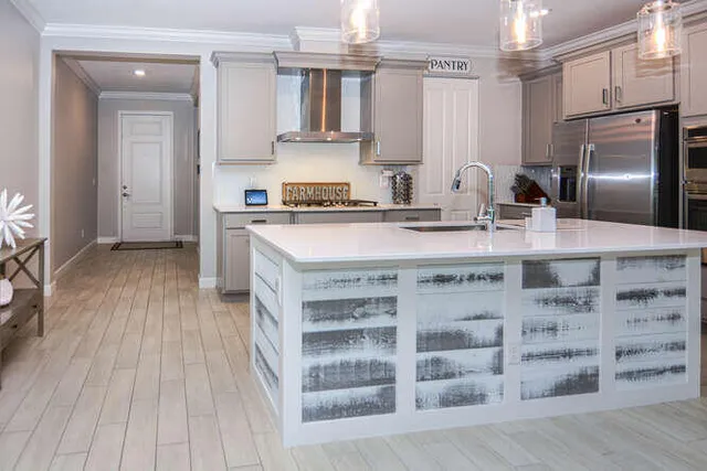 a kitchen with a center island wooden floor and stainless steel appliances