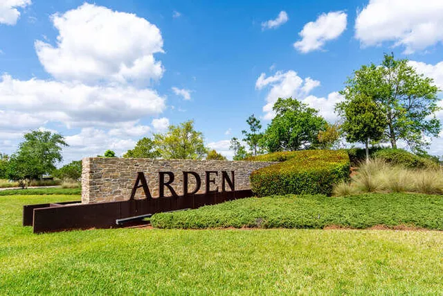 a front view of a building with a garden and plants
