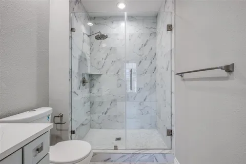 a bathroom with a shower a toilet and a sink