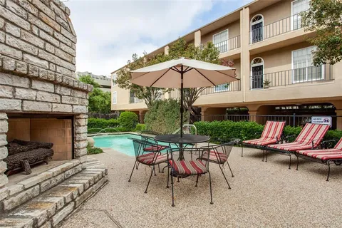a view of a patio with a table and chairs under an umbrella