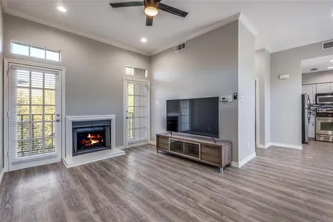 an empty room with furniture wooden floor fireplace and windows