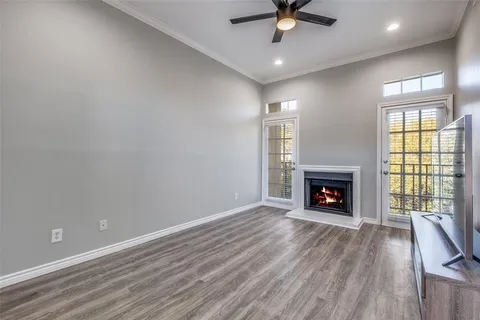 an empty room with windows fireplace and wooden floor