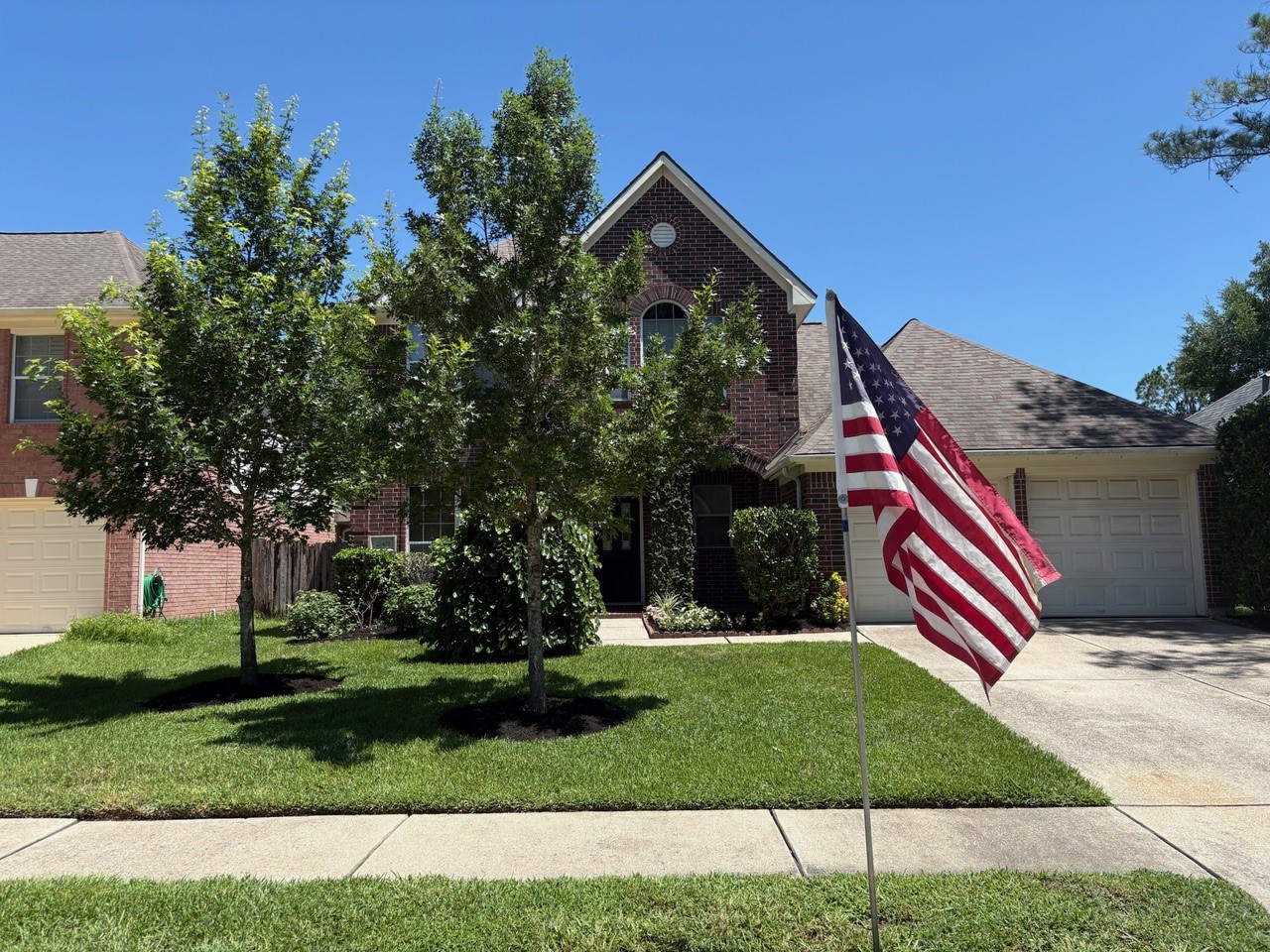 22402 Rue Canyon Court Katy, TX 77450 - Photo 2 of 18 Proudly fly your colors! This perspective emphasizes the home’s inviting, neighborly charm under a clear blue sky. It’s easy to envision quiet afternoons enjoying the front yard and greeting neighbors in this highly desirable, established community.
