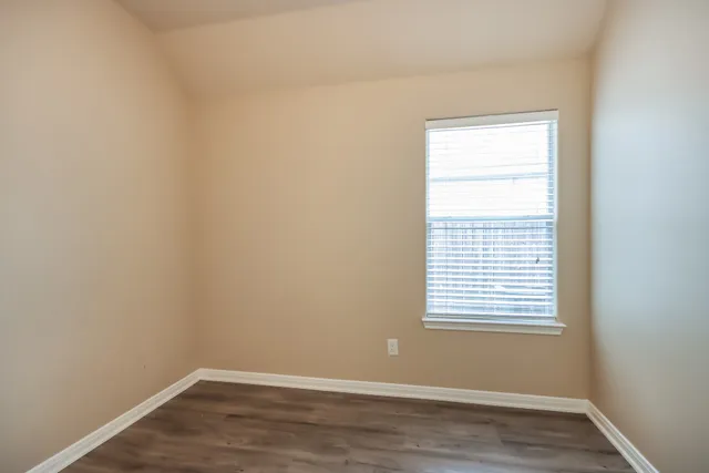 a view of a small space with wooden floor and a window