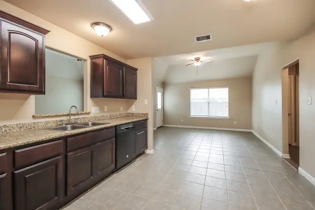 a bathroom with a granite countertop sink mirror and cabinets