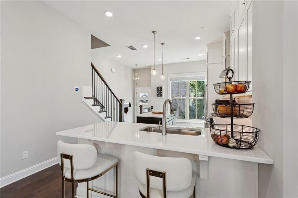 4219 Deming Circle Sandy Springs, GA 30342 - Photo 16 of 47 a kitchen with stainless steel appliances kitchen island granite countertop a table chairs and a refrigerator