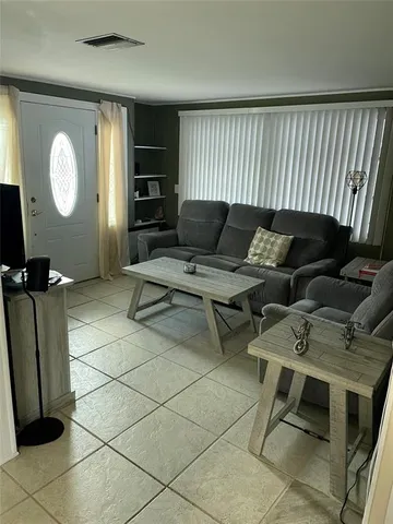 a living room with couches chair and piano