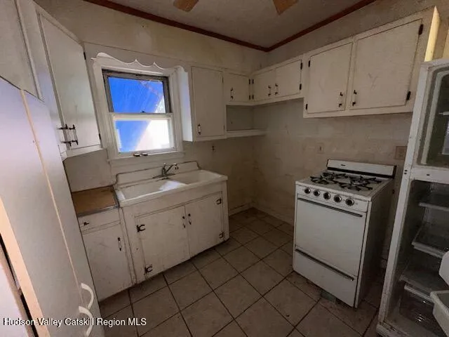 a kitchen with sink a stove and cabinets