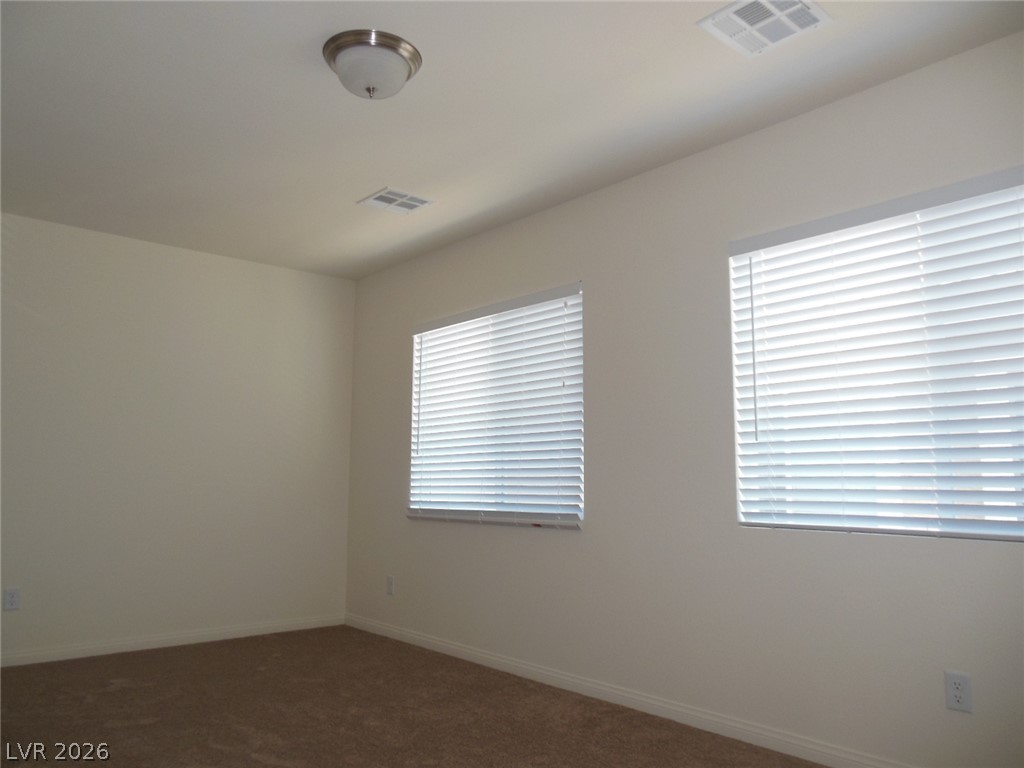 6390 Jackson Spring Road Las Vegas, NV 89118 - Photo 15 of 27 A well-lit bedroom offering a neutral palette and ample natural light from multiple windows.