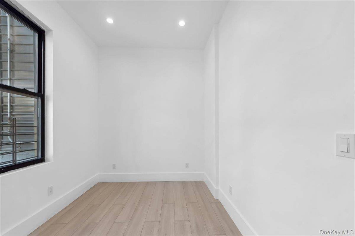 953 Tilden Street Bronx, NY 10469 - Photo 12 of 24 a view of a small space with wooden floor and a window