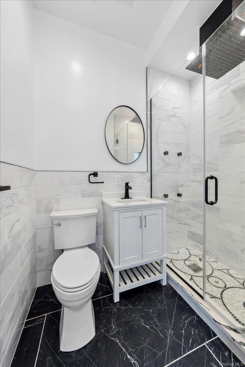 953 Tilden Street Bronx, NY 10469 - Photo 18 of 24 a bathroom with a toilet sink and mirror