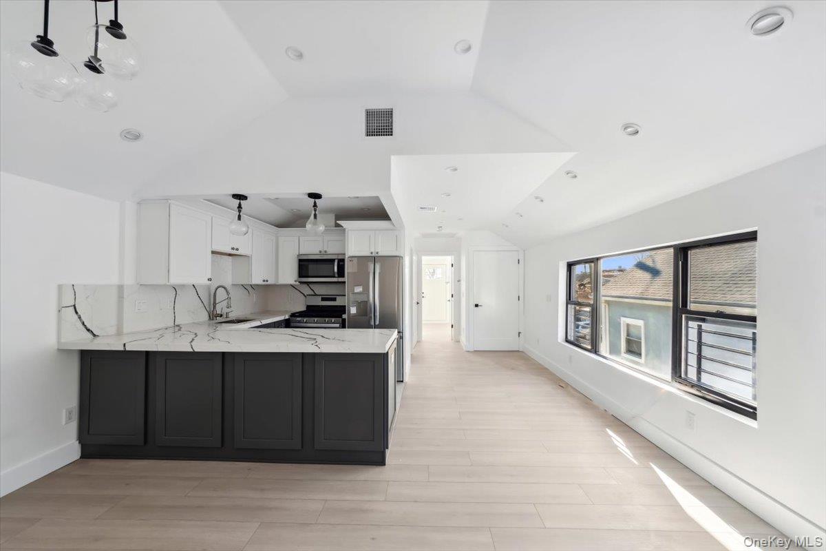 953 Tilden Street Bronx, NY 10469 - Photo 3 of 24 a kitchen with stainless steel appliances a sink stove and cabinets