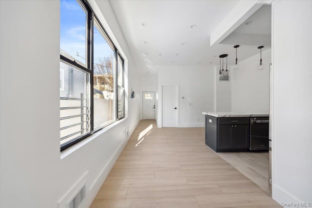 953 Tilden Street Bronx, NY 10469 - Photo 10 of 24 a view of a hallway with wooden floor and windows