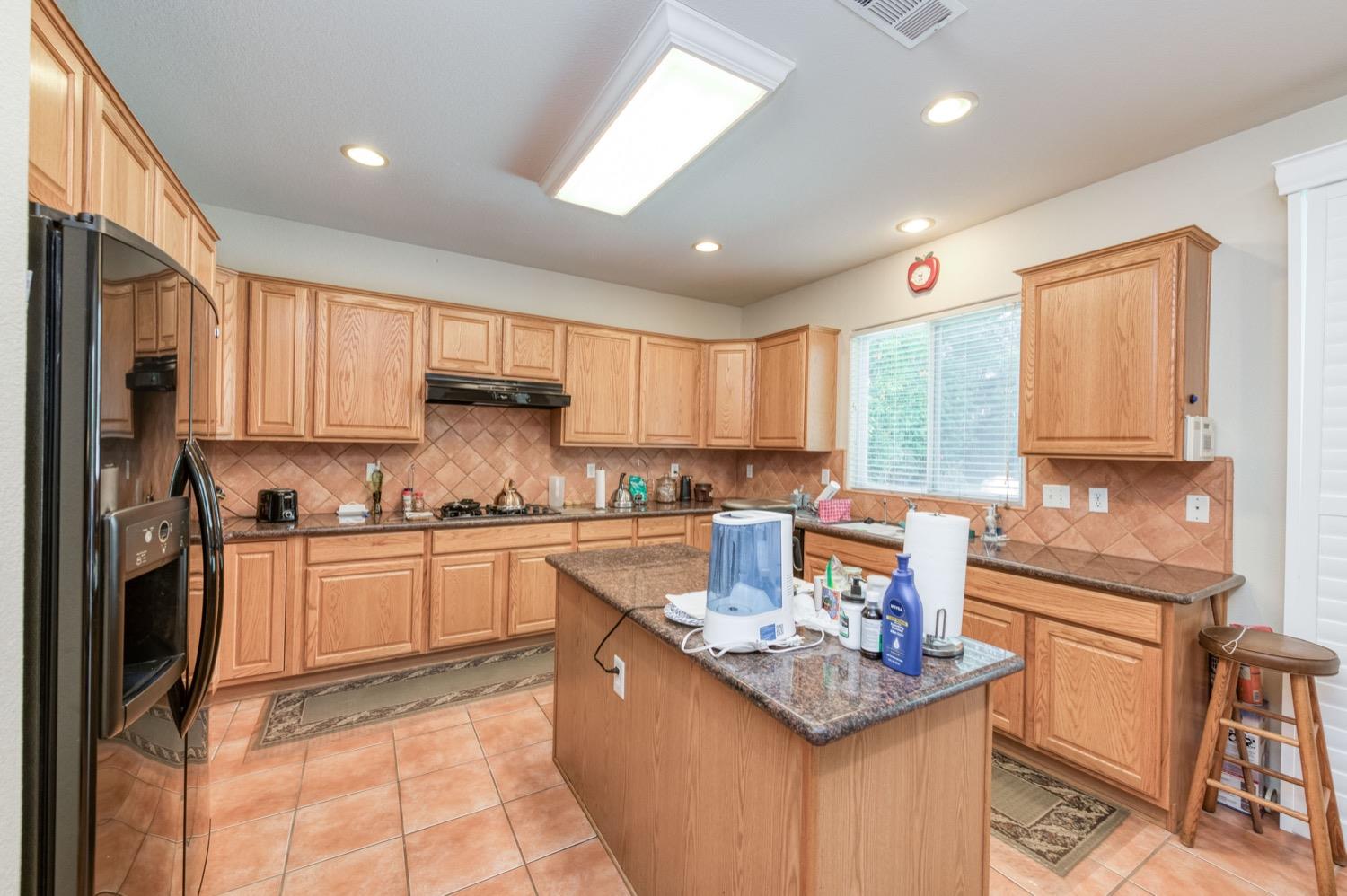 2661 Buckingham Avenue Clovis, CA 93611 - Photo 14 of 50 a kitchen with stainless steel appliances granite countertop a stove a sink dishwasher and a refrigerator