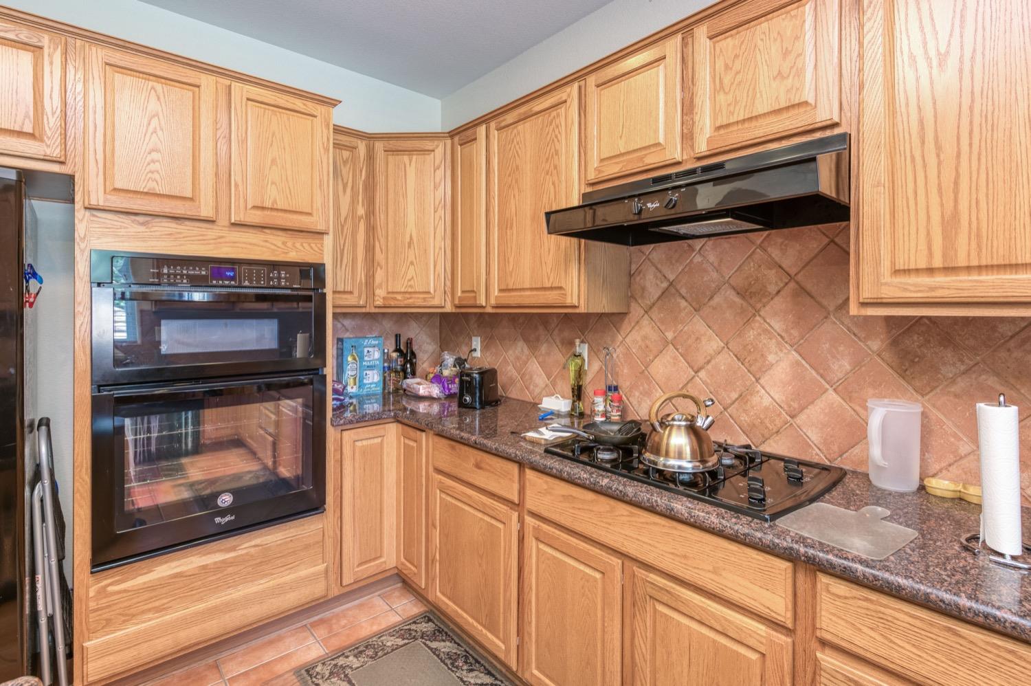 2661 Buckingham Avenue Clovis, CA 93611 - Photo 15 of 50 a kitchen with granite countertop cabinets stainless steel appliances and a window