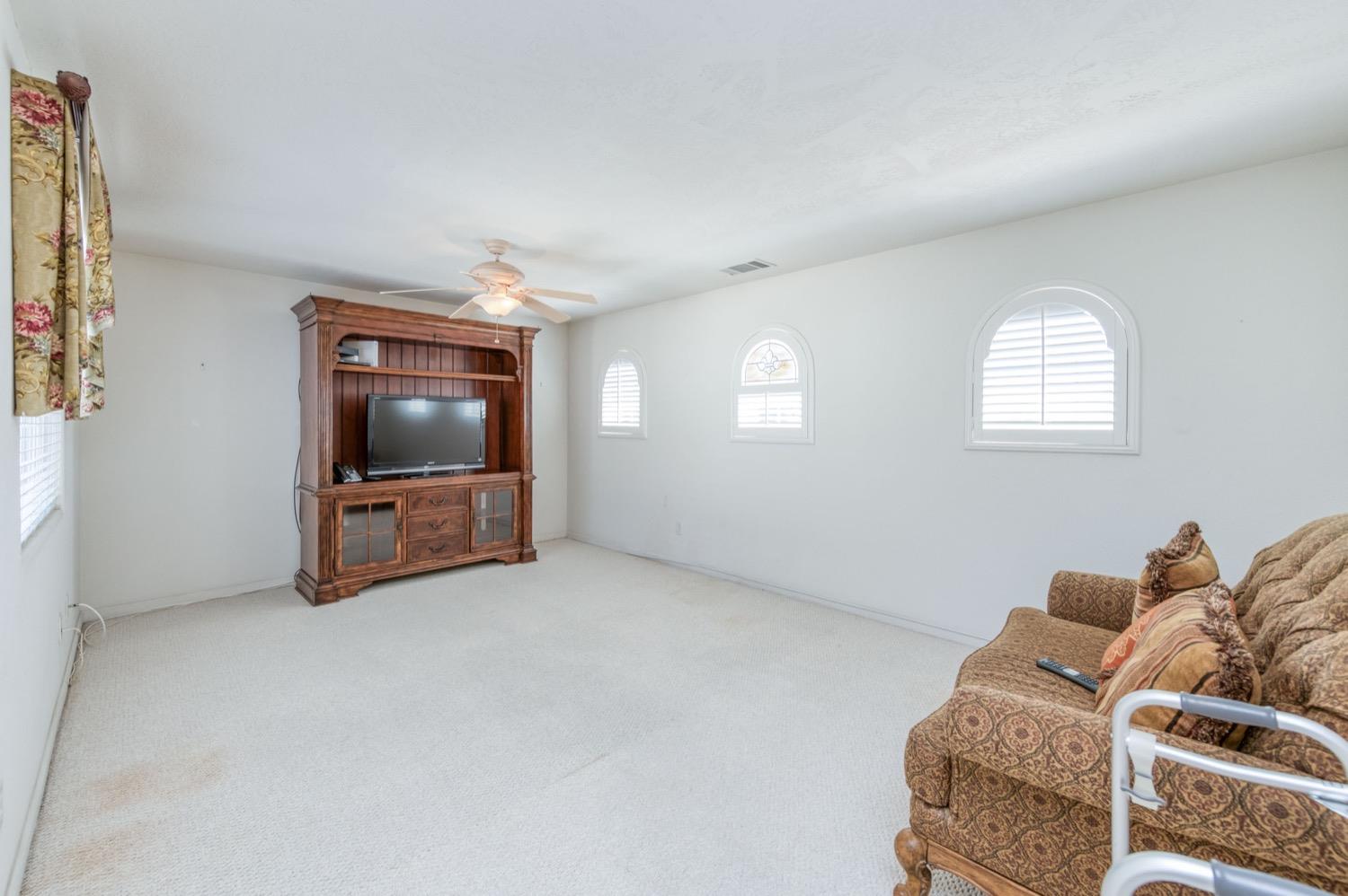 2661 Buckingham Avenue Clovis, CA 93611 - Photo 23 of 50 a living room with furniture a flat screen tv and a window