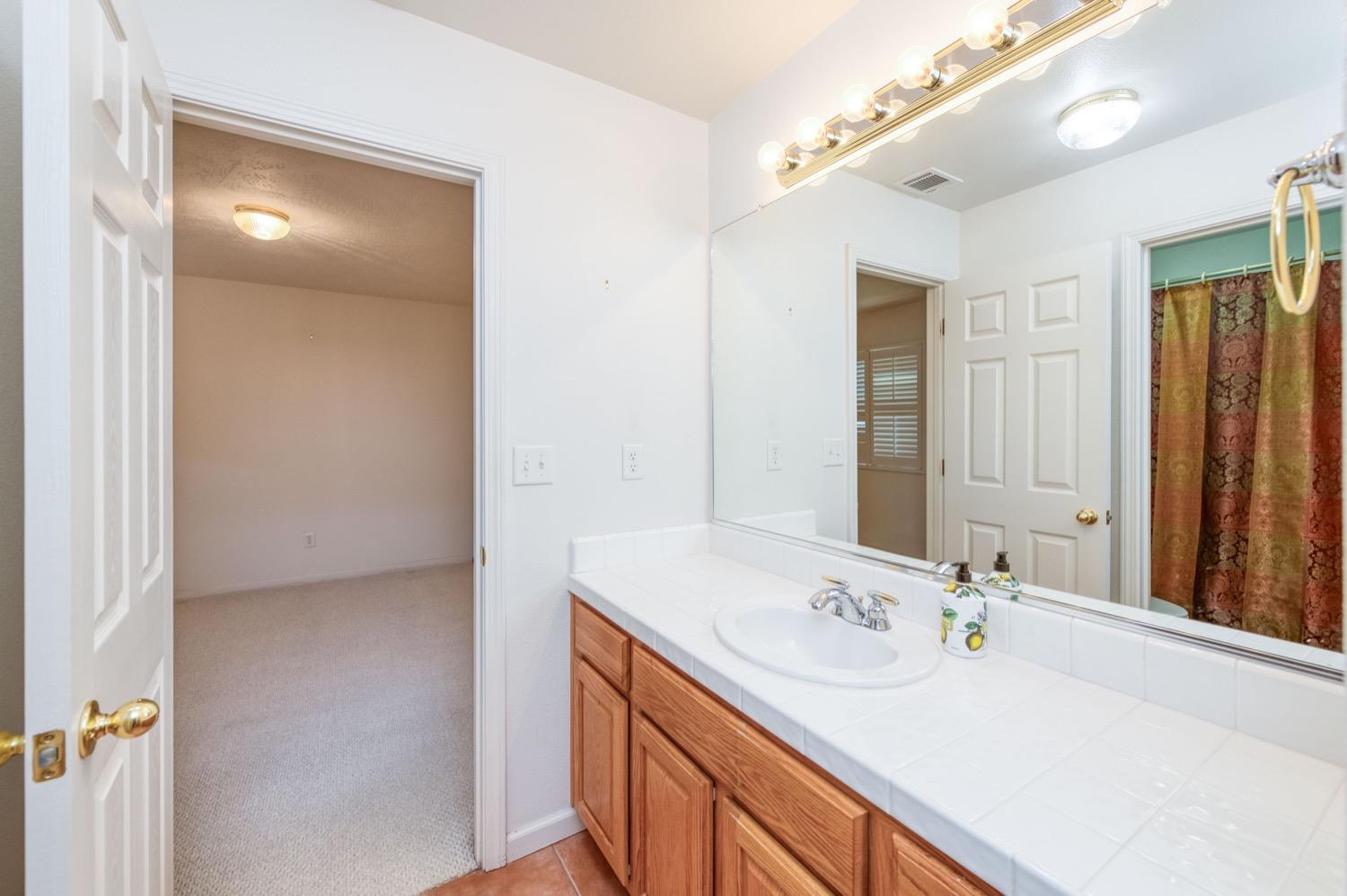 2661 Buckingham Avenue Clovis, CA 93611 - Photo 28 of 50 a bathroom with a sink and a mirror