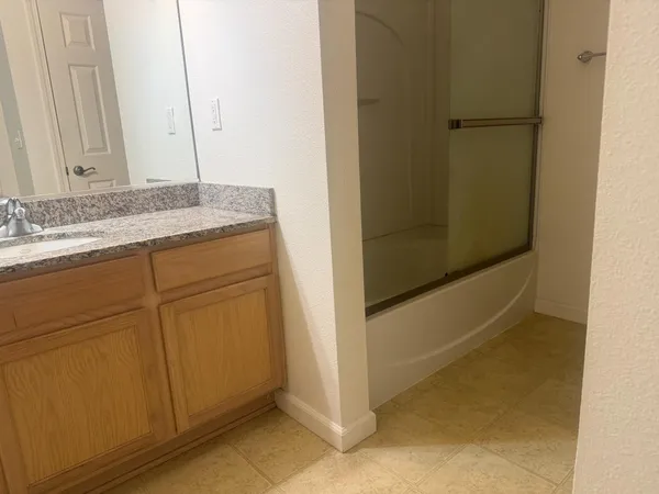 a bathroom with a granite countertop sink and a mirror