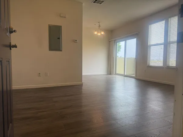 an empty room with wooden floor and windows