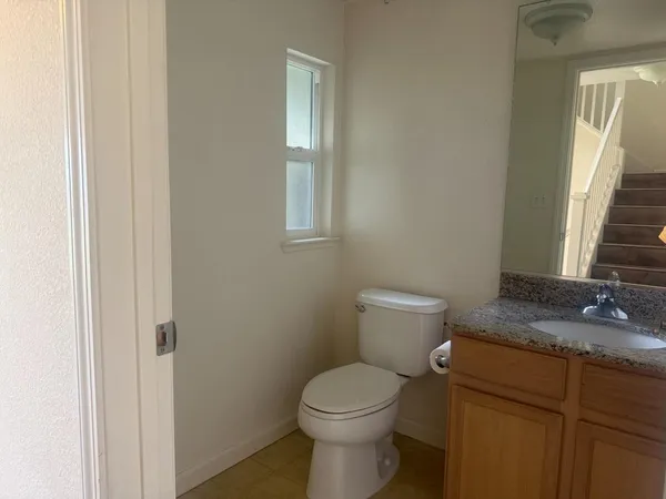 a bathroom with a granite countertop toilet and a sink