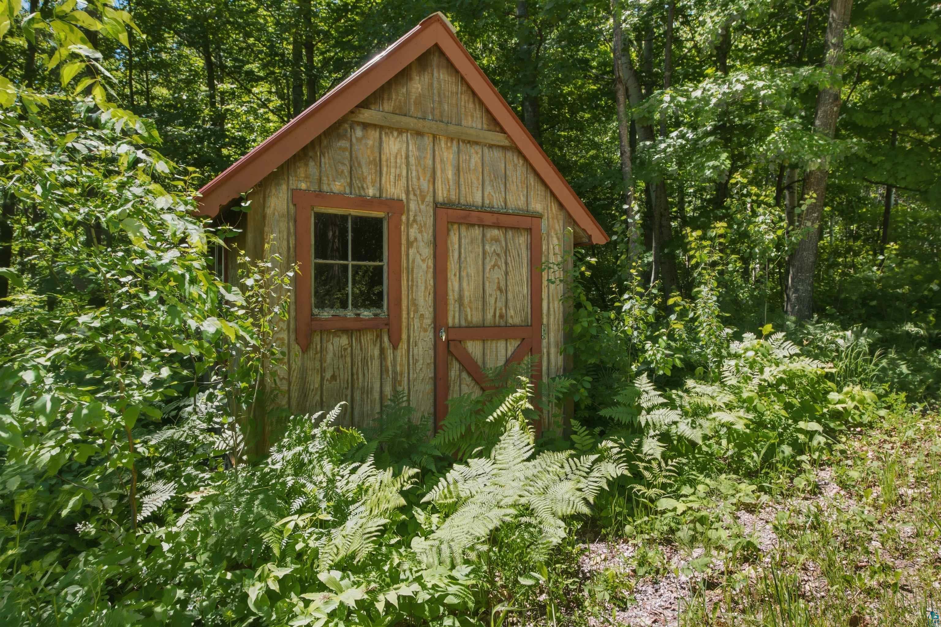 86270 Meyers-Olson Road Bayfield, WI 54814 - Photo 27 of 33 Wood-paneled outbuilding with a peaked roof and red trim