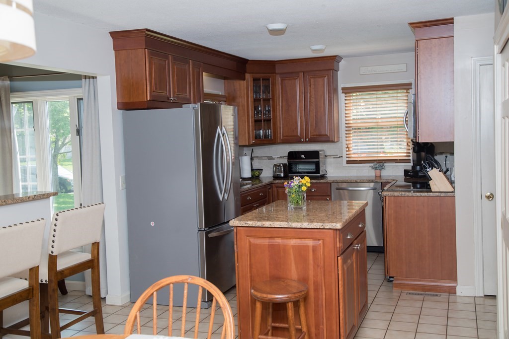 22 Deer Run Road West Springfield, MA 01089 - Photo 4 of 38 a kitchen with stainless steel appliances granite countertop a refrigerator a sink a stove a dining table and chairs
